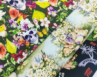 May include: Three rolls of patterned fabric. One features skulls, flowers, and butterflies on a dark background. Another depicts bunnies, daisies, and Easter eggs. The third has a tropical design with text that reads "Hula Baby!"