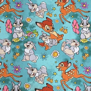 Könnte beinhalten: Ein blaugrüner Stoff mit einem sich wiederholenden Muster von Bambi und Klopfer. Das Muster zeigt Bambi beim Laufen, Klopfer mit einer Blume in der Hand und beide Figuren mit Blumen und Schmetterlingen.