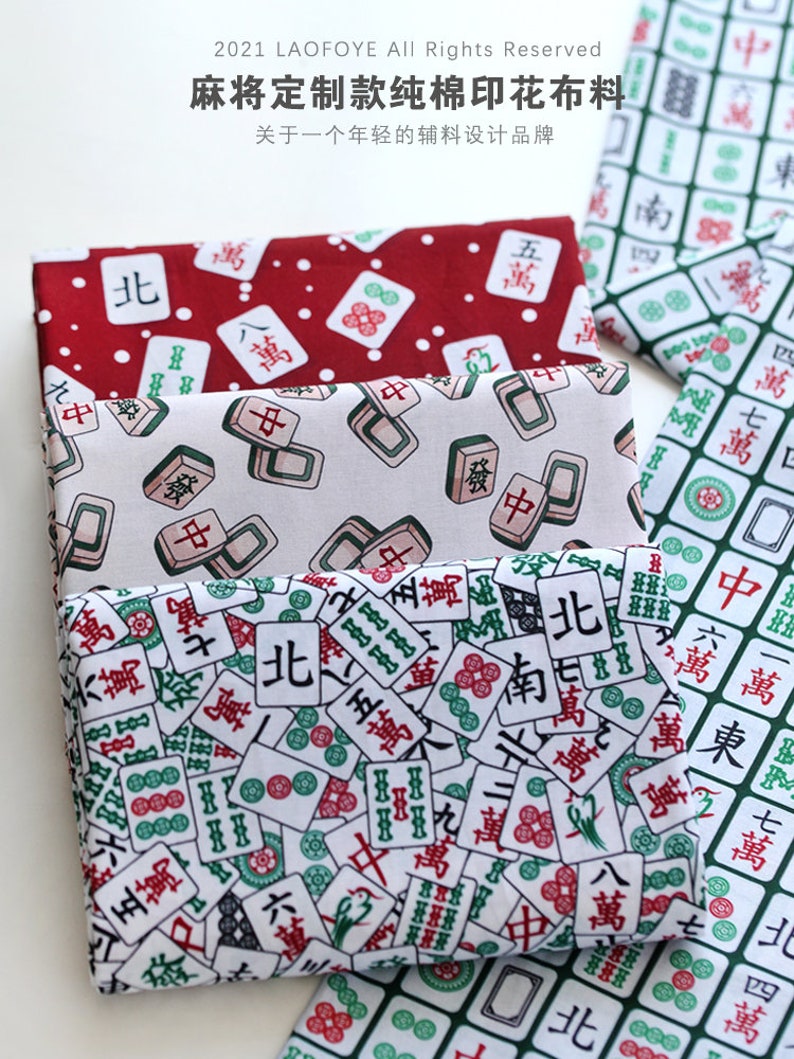 May include: Three pieces of fabric with a white background and a repeating pattern of green and red mahjong tiles. The tiles have Chinese characters on them. The fabric is for sale.