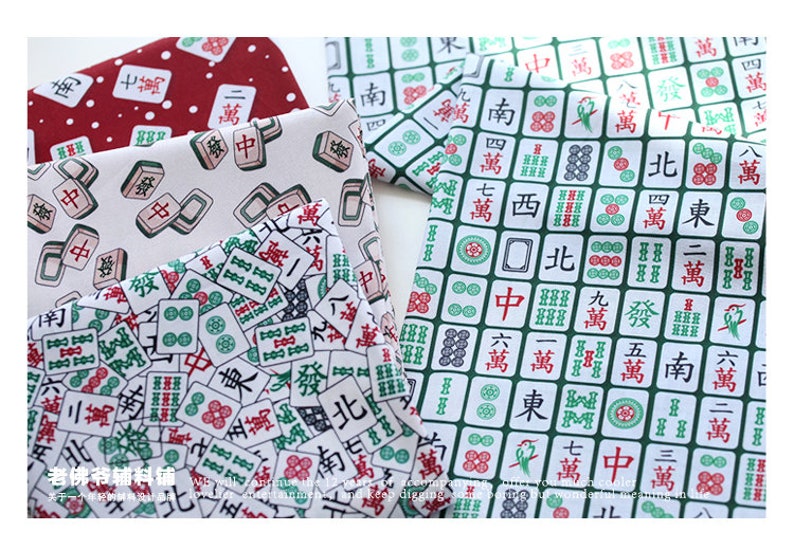 May include: A collection of fabric squares featuring a repeating pattern of mahjong tiles in various colors, including green, red, white, and black. The tiles are arranged in a grid pattern and feature Chinese characters.