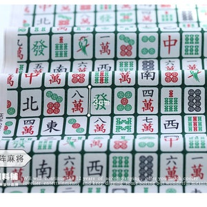 May include: A white fabric with a repeating pattern of green and white mahjong tiles. The tiles feature Chinese characters and symbols. The fabric is 3 cm wide.