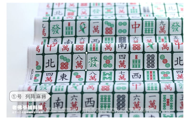 May include: A white fabric with a repeating pattern of green and white mahjong tiles. The tiles feature Chinese characters and symbols. The fabric is 3 cm wide.