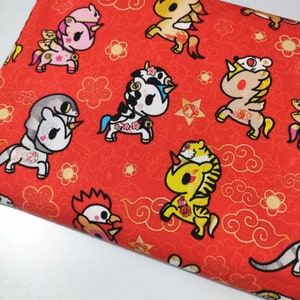 May include: Red fabric with a repeating pattern of colourful cartoon unicorns, dragons, and other mythical creatures. The background features gold clouds and flowers.