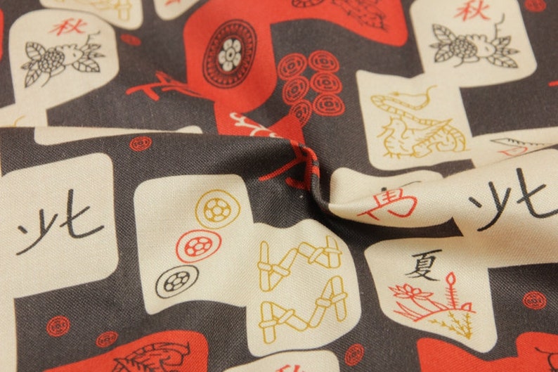 May include: Close-up of fabric with a repeating pattern of red and gold illustrations on a dark gray background. The design includes stylized figures, circles, and Chinese characters on off-white squares.