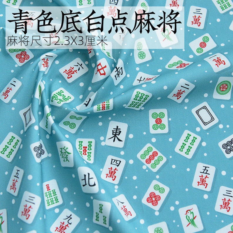 May include: A blue fabric with white dots and a repeating pattern of white mahjong tiles. The tiles have Chinese characters and symbols. The text on the fabric reads "Green background white dot mahjong tiles. Tile size 2.3x3 cm."