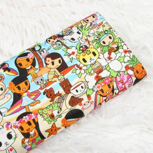 May include: A colourful fabric with a repeating pattern of cartoon characters, flowers, and tropical elements. The characters are mostly girls with flowers in their hair and wearing colourful outfits. The fabric has a white background with a light blue stripe running horizontally across the centre.