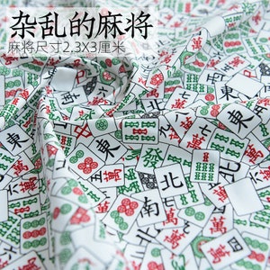 May include: White fabric with a repeating pattern of Chinese mahjong tiles. The tiles are green, red, and black with white characters. The text on the fabric reads "杂乱的麻将 麻将尺寸2.3X3厘米", which translates to "Messy Mahjong Mahjong Size 2.3X3 cm".