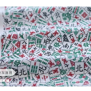 May include: White fabric with a repeating pattern of green and red mahjong tiles. The tiles feature Chinese characters and symbols. The fabric is perfect for crafting projects, quilting, and home decor.