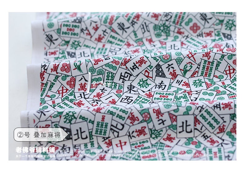 May include: White fabric with a repeating pattern of green and red mahjong tiles. The tiles feature Chinese characters and symbols. The fabric is perfect for crafting projects, quilting, and home decor.