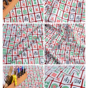 May include: White fabric with a repeating pattern of red and green mahjong tiles. The tiles feature Chinese characters and symbols.