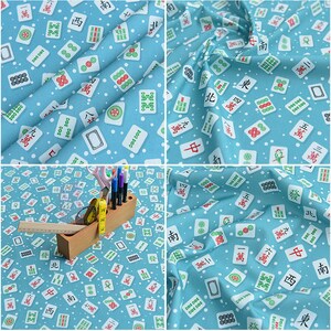May include: A blue fabric with a white background featuring a repeating pattern of Mahjong tiles. The tiles have Chinese characters and symbols in red, green, and black. The fabric is perfect for crafting projects, quilting, and home decor.