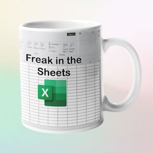 Peut inclure: Une tasse en céramique blanche avec un motif de feuille de calcul Microsoft Excel vert et blanc. La tasse porte l'inscription "Freak in the Sheets".