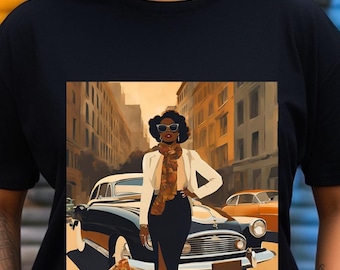 May include: A black short-sleeved t-shirt featuring a graphic print of a person wearing a white jacket, a patterned scarf, and sunglasses, standing in front of a vintage car on a city street with buildings in the background and a warm color palette.