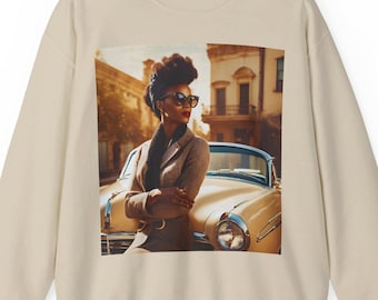 May include: A beige sweatshirt with a graphic print of a woman wearing sunglasses and a brown jacket standing next to a vintage car.