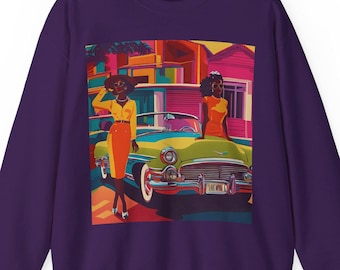 May include: Purple sweatshirt with a graphic print of two women standing next to a green vintage car in front of a colorful building. The women are wearing yellow and red dresses. The car has a license plate that says "LIKE NO"