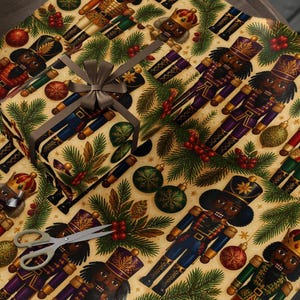 May include: Wrapping paper featuring a repeating pattern of nutcracker figures in various uniforms, interspersed with green pine branches, red berries, and gold and green ornaments. A gift box wrapped in the same paper has a grey ribbon bow.