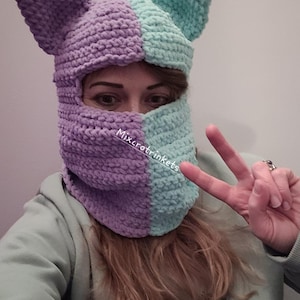 May include: A purple and light blue crocheted cat-eared balaclava with the text "Mixcrotinkets" on the front.