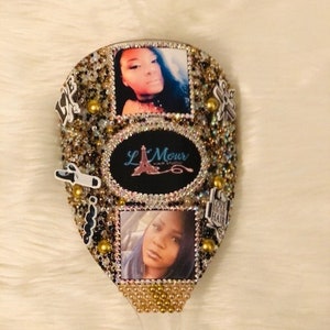 May include: A gold and black hairbrush with rhinestones and two photos of women. The brush has the text "L'Mour" and "Love Your Hair" on it.