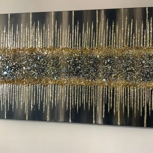 Puede incluir: Pintura abstracta con fondo negro y purpurina dorada y plateada. La purpurina est&aacute; dispuesta en forma de goteo.