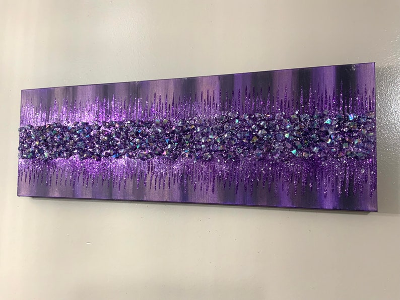 K&ouml;nnte beinhalten: Lila und schimmernde Glitzerkunst auf Leinwand mit einer strukturierten, geschichteten Wirkung. Der Glitzer ist in einem horizontalen Band &uuml;ber die Leinwand angeordnet.