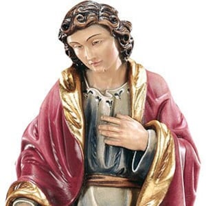 May include: A detailed statue of a saint, featuring a figure in a red and gold robe, with a lion at its feet. The statue includes tools and nails, and is made of a stone-like material. The figure has a serene expression.