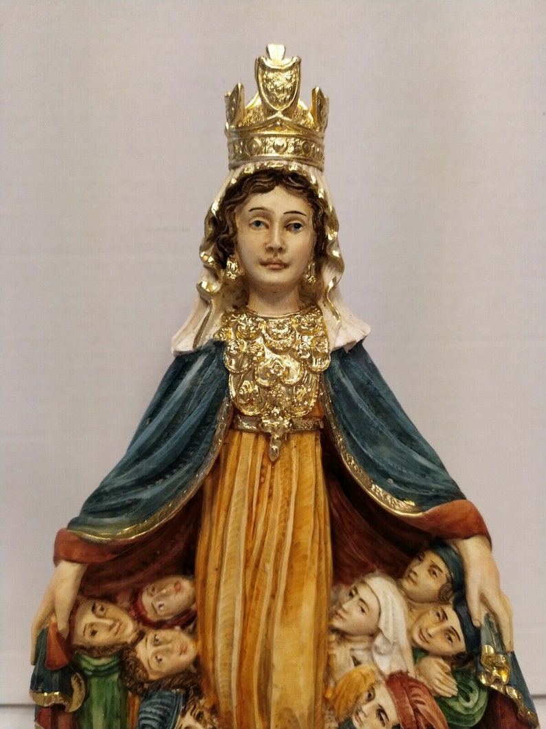 以下が含まれることがあります： 金色の冠と青いローブを着た女性の置物で、腕に人々を抱えています。女性は穏やかな表情をしており、宗教的な人物として描かれています。