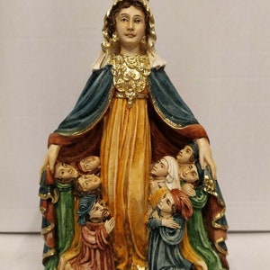 以下が含まれることがあります： 王冠と青と金のローブを着た聖母マリアの置物。彼女はすべてひざまずいて彼女を見上げている子供たちのグループに囲まれています。置物の台座は黒で、「BAY OF PONCE DE LEON, PUERTO RICO」と書かれています。