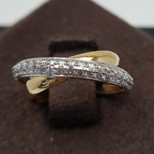 Può includere: Un anello in oro e diamanti bianchi con un design a croce. L'anello è incastonato con piccoli diamanti.