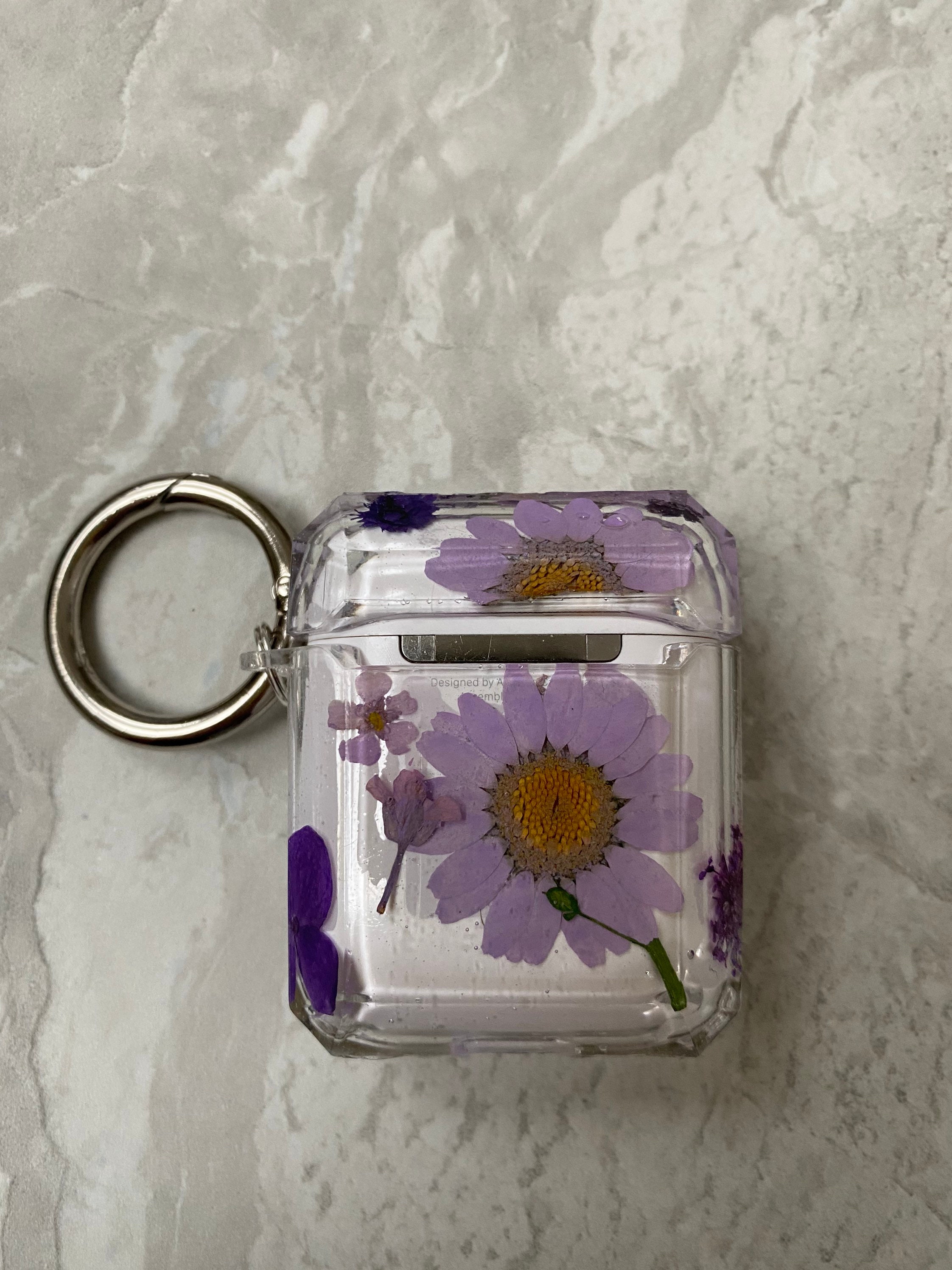 Clear Resin AirPod case filled with Purple flowers with a Etsy