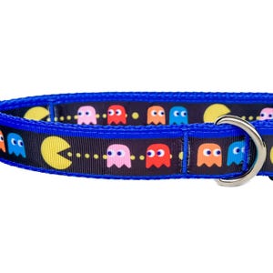 May include: A blue dog collar with a black background and a repeating pattern of Pac-Man ghosts in various colors.