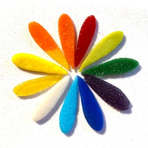 May include: A flower-shaped arrangement of glass pieces, each a different colour of the rainbow, from red to purple.