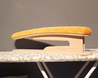 May include: A wooden ironing board with a yellow padded top. The board is designed to be used on top of a standard ironing board.