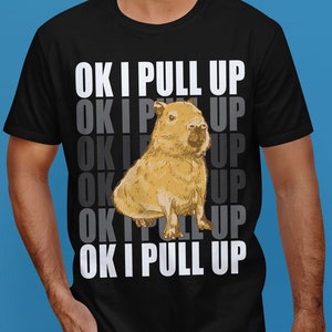 May include: A black t-shirt with a white graphic of a capybara and the text "OK I PULL UP" repeated multiple times.