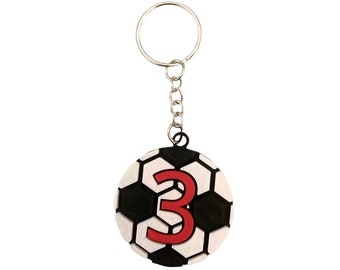 May include: A black and white soccer ball keychain with a red number 3 on it.