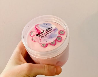 Może przedstawiać: Różowy slime w przezroczystym plastikowym pojemniku z białą pokrywką. Pokrywka ma naklejkę z tekstem "Winnie's Slime" i "Dzięki za zamówienie! Mam nadzieję, że ci się spodoba!"