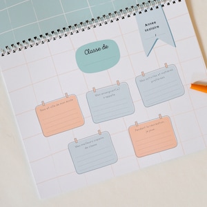 May include: A light blue and peach colored printable worksheet with a grid pattern. The worksheet has several sections with headings in French, including "Classe de", "Nom et ville de mon ecole", "Mon enseignant(e)", "Mes activites et matieres preferes", "Mes meilleurs copains de classe", and "Pendant la recreation, je joue".
