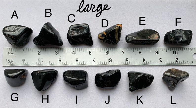 A photo of all of the large stones, labelled with their corresponding letters, lined up against a ruler (in inches). Stones A, B, C, D, E, and F are shown above the ruler and stones G, H, I, J, K, and L are shown below it.