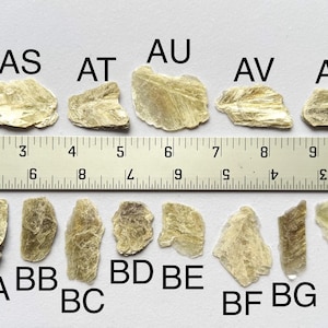 A photo of stones AR-BH lined up against a ruler (in inches), labelled with their respective letters.