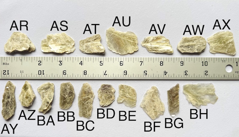 A photo of stones AR-BH lined up against a ruler (in inches), labelled with their respective letters.