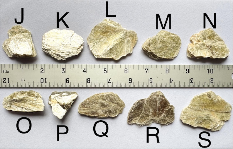 A photo of stones J-S lined up against a ruler (in inches), labelled with their respective letters.