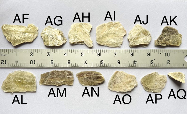 A photo of stones AF-AQ lined up against a ruler (in inches), labelled with their respective letters.