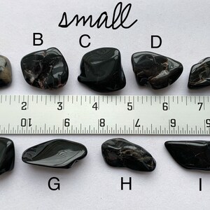 A photo of all of the small stones, labelled with their corresponding letters, lined up against a ruler (in inches). Stones A, B, C, D, and E are shown above the ruler and stones F, G, H, and I are shown below it.