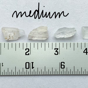 A photo of all of the medium stones lined up against a ruler (in inches).