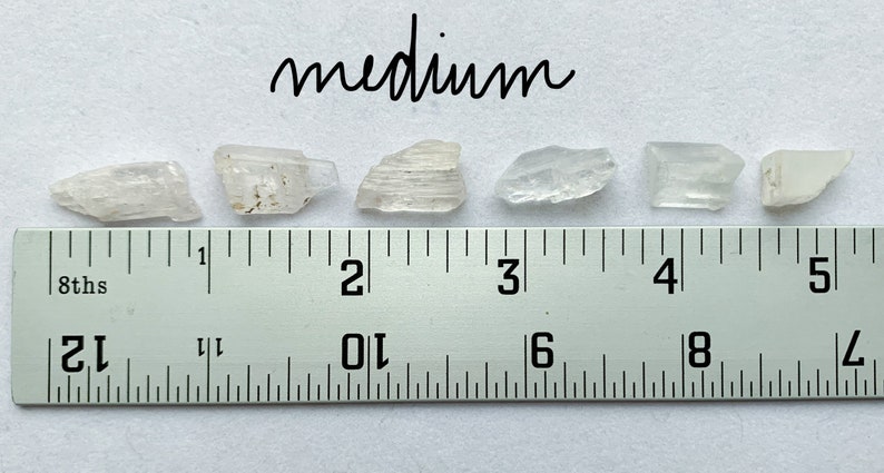 A photo of all of the medium stones lined up against a ruler (in inches).