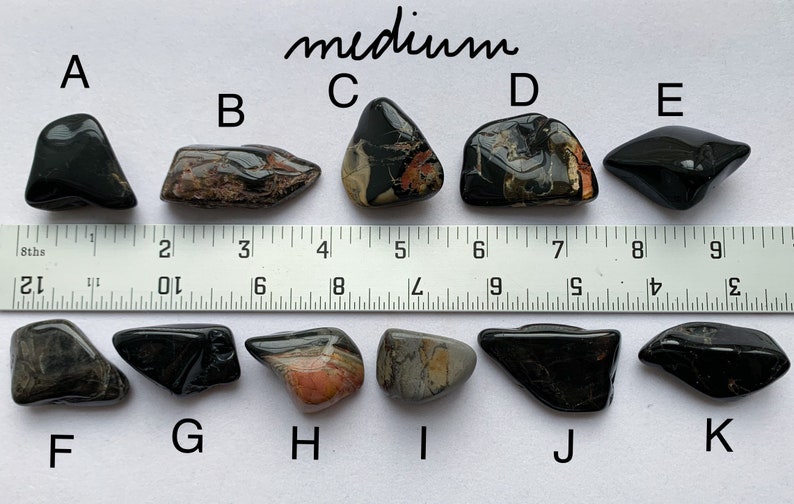 A photo of all of the medium stones, labelled with their corresponding letters, lined up against a ruler (in inches). Stones A, B, C, D, and E are shown above the ruler and stones F, G, H, I, J, and K are shown below it.