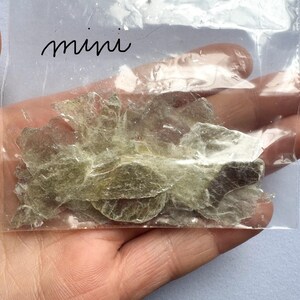 A photo of the lot of mini stones/flakes in a plastic zip bag being held in my hand.
