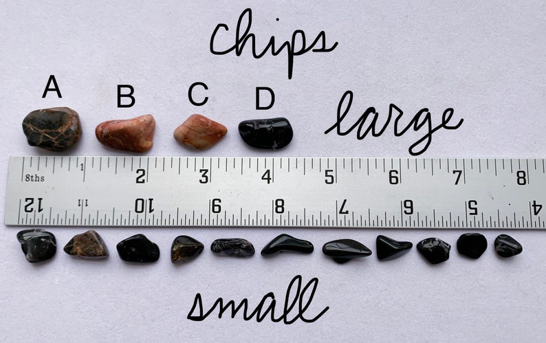 A photo of all of the "chips" stones lined up against a ruler (in inches). The "large chips" are shown above the ruler, labelled with their corresponding letters, and the "small chips" are shown below it.