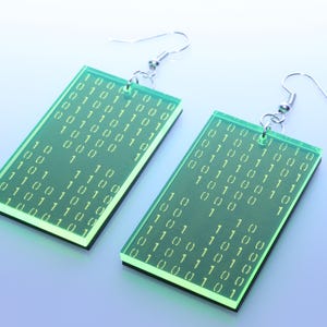 Könnte beinhalten: Eine weiße Keramik-Tasse mit schwarzem Henkel und dem Text "But First, Coffee" in schwarzer, handschriftlicher Schrift. Die Tasse steht auf einer weißen Oberfläche.