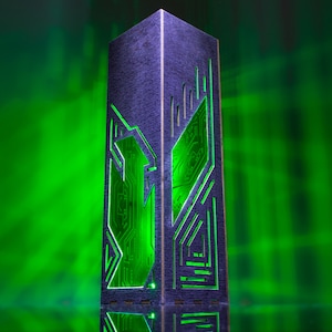 Peut inclure: Une lampe en bois gris foncé avec une lumière verte qui brille à travers un motif découpé de circuits imprimés.