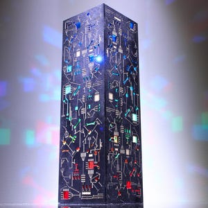 May include: A black and blue decorative tower with a circuit board design. The tower is made of metal and has a textured surface.